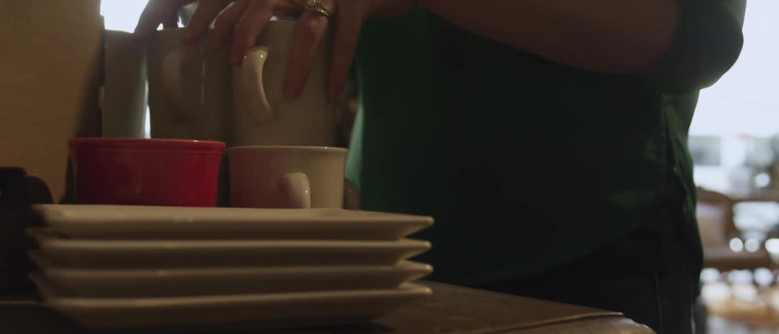 A person grabbing clean dishes