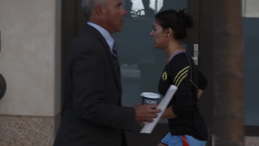 A woman jogs on a city sidewalk