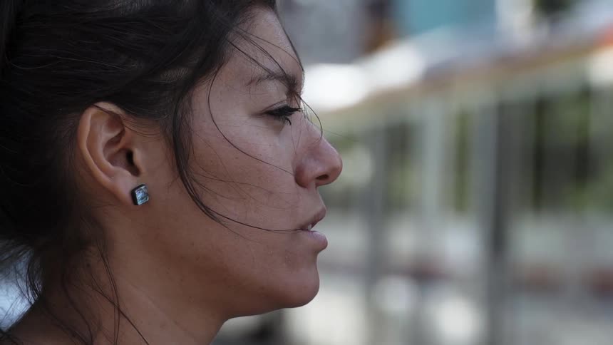 A woman is waiting for a train and blinking