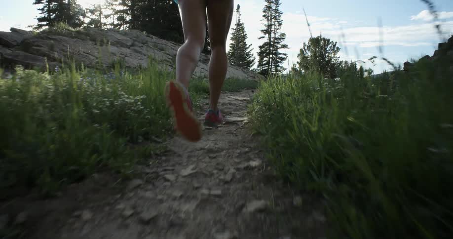 A person is running uphill on a trail