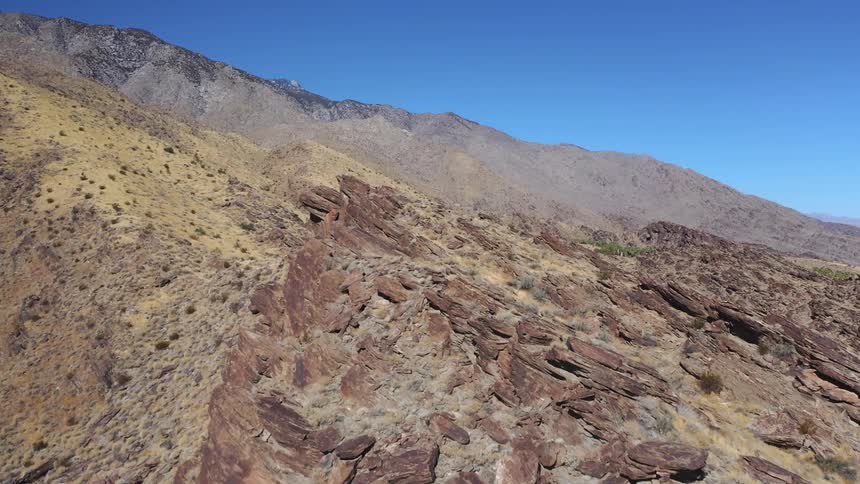 Sparse vegetation dots a rocky and desolate mountainside