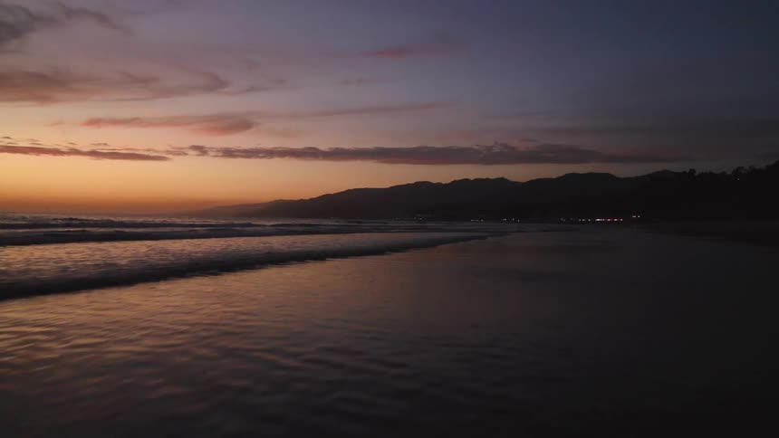 An aerial shot of a beach at sunset