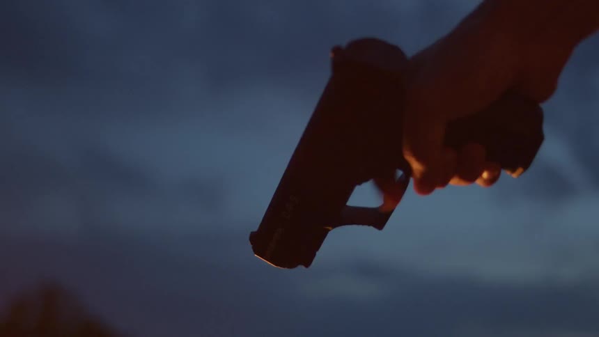 A person rapidly pulling a gun trigger while the gun is pointed down