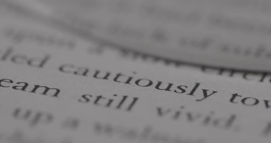 A magnifying glass panning over words in a book