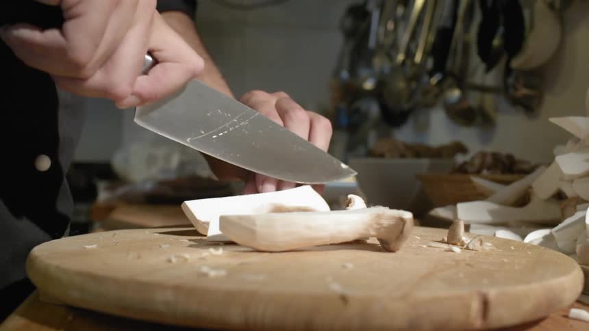 Someone cuts up mushrooms