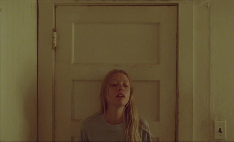 A woman runs to a room and closes the door putting on headphones