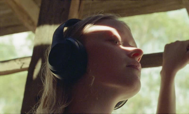 A girl in a wooden structure listened to headphones