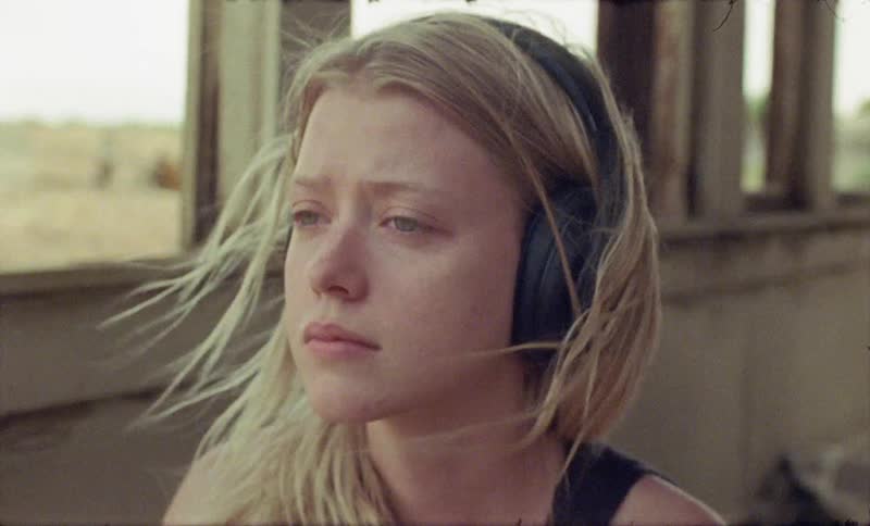 A woman is listening to headphones on a windy day