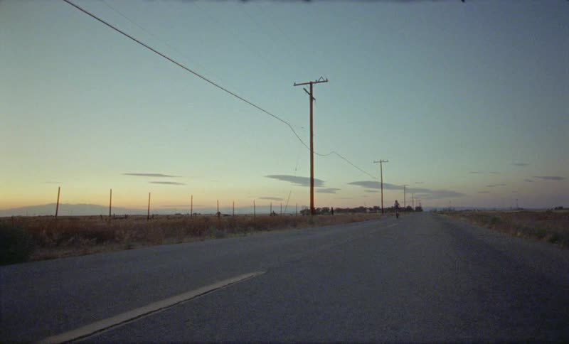 Bicycle is being ridden down the road near the fields