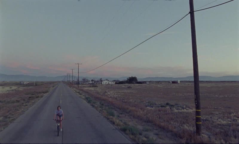Vintage video of a person riding a bike on a road