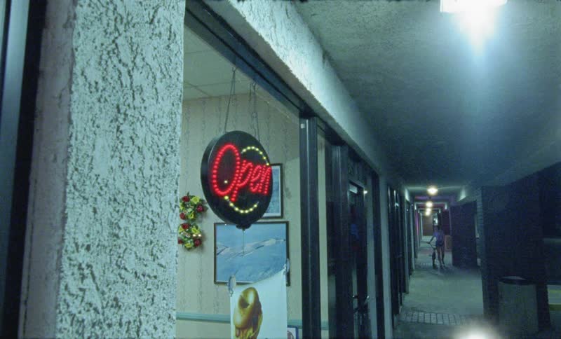 A open sign flashes in the window of a business