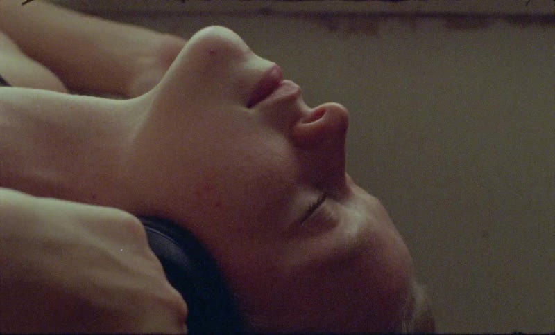 A woman is laying back listening to headphones