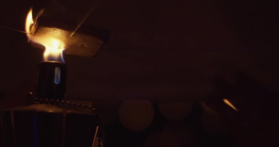 An object is being lit by fire in a dark area