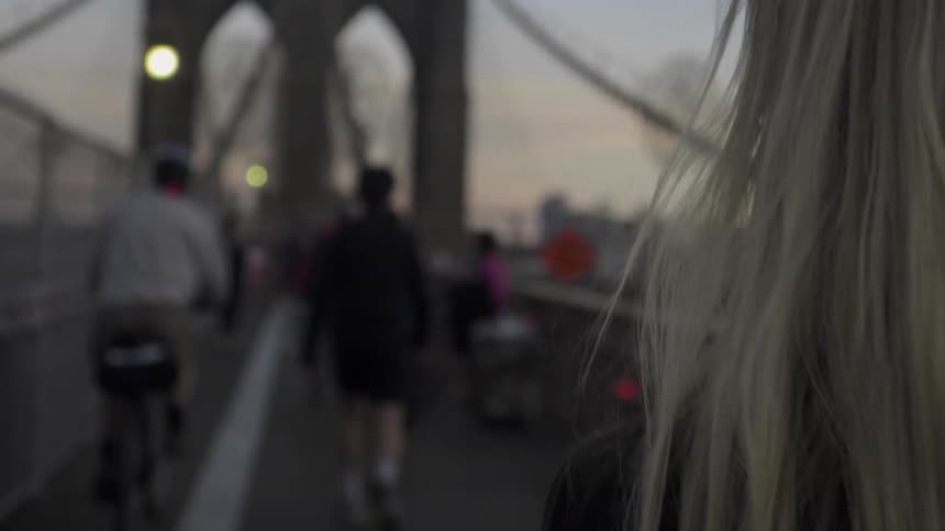 A blonde woman walking down a busy street