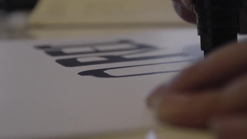 A person is writing with a marker on paper
