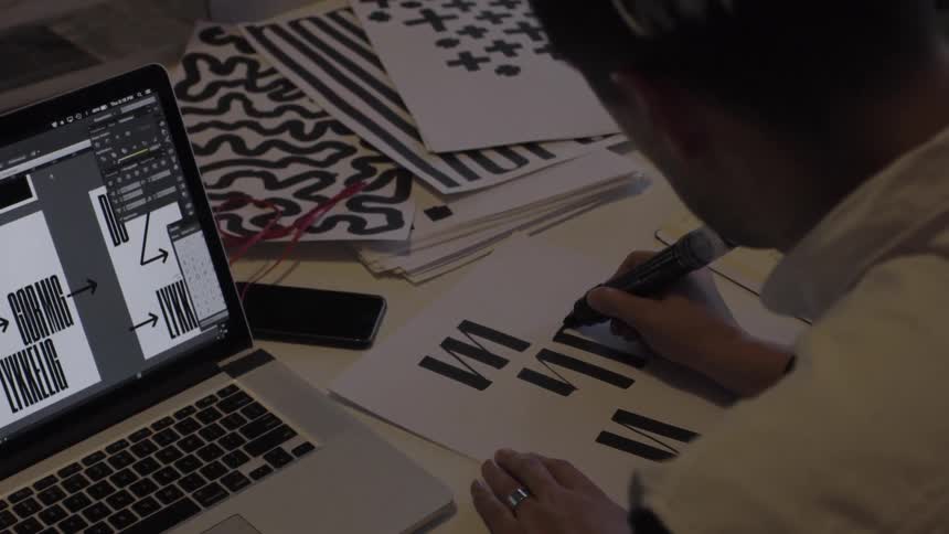 A person replicates art with a marker while sitting at a desk