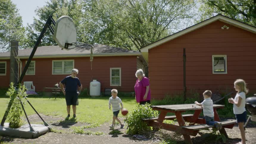 A family play in the yard with a basketball