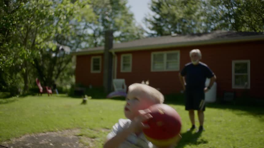 A young boy throws a ball into the air