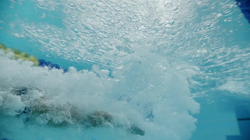 A white male dives into a swimming pool