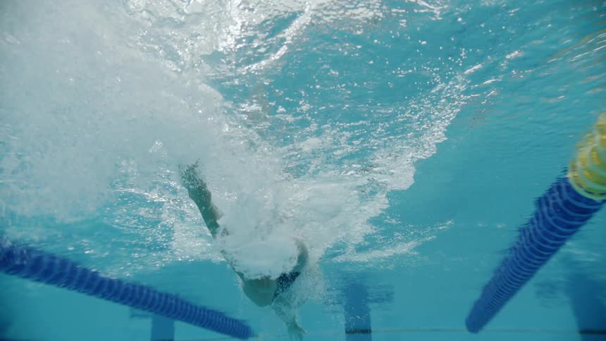 A man is swimming in the pool underwater
