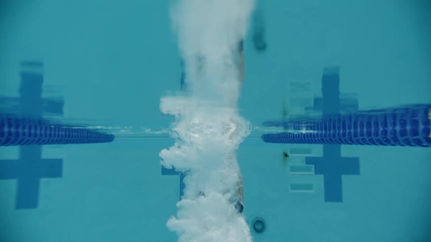 A young girl dives in to a swimming pool