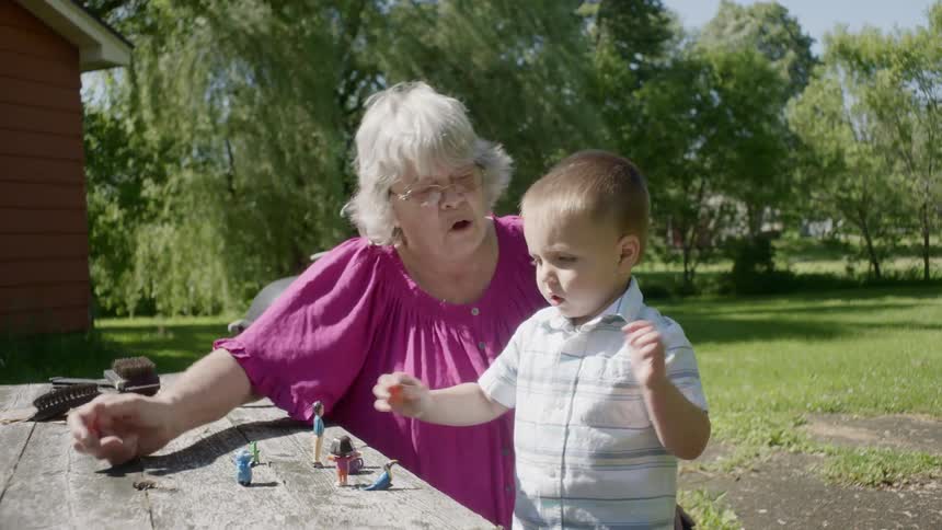 An elderly woman plays with a little boy