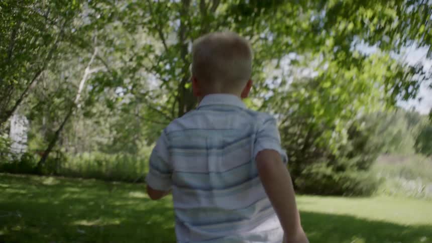 A little boy runs outside
