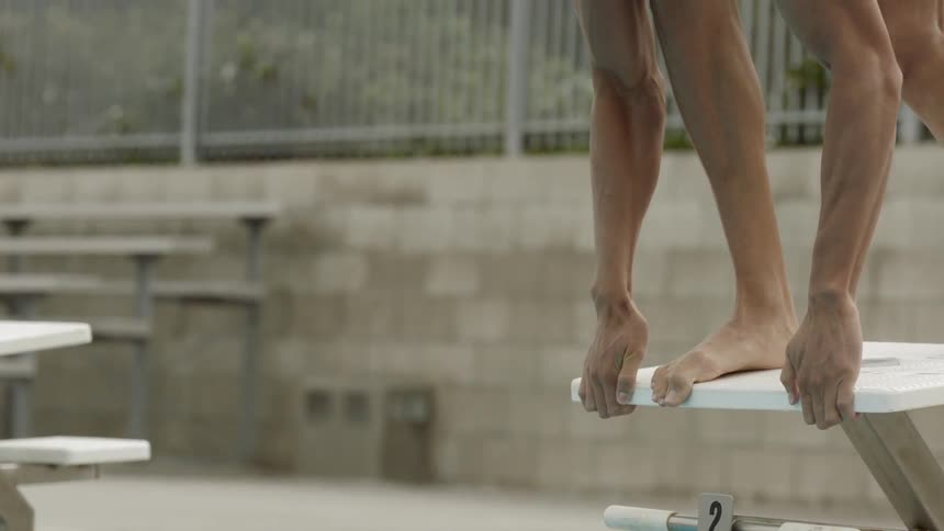 A white man dives into a swimming pool