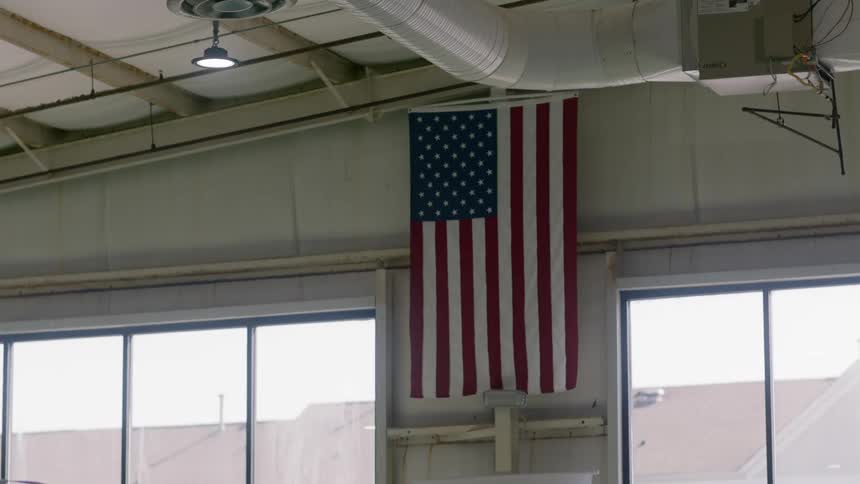 A flag is hanging in the hall near the window