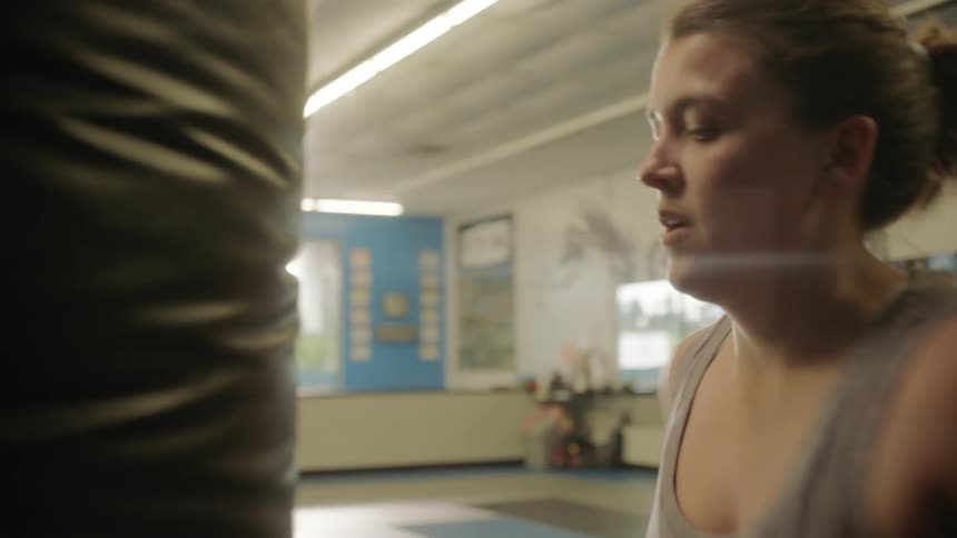 A woman is punching the heavy bag fast