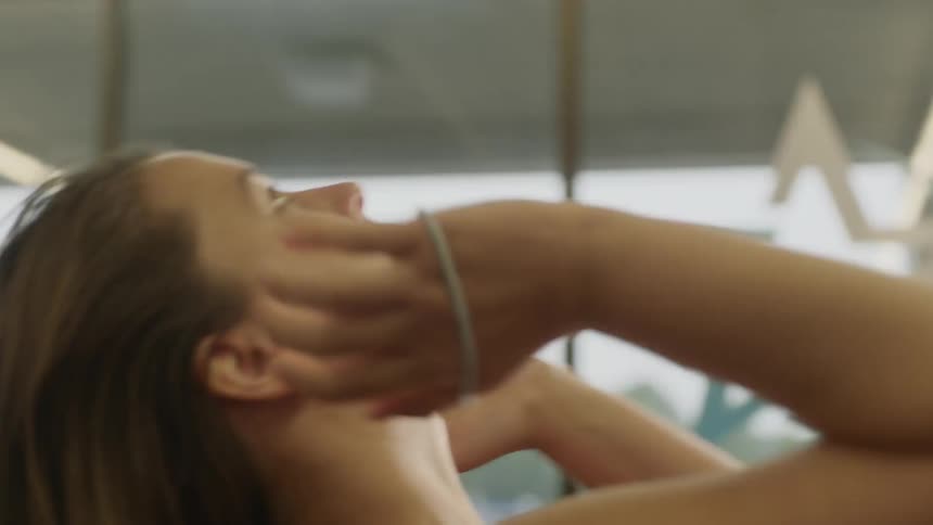 A woman using a hairband to tie her hand into a ponytail