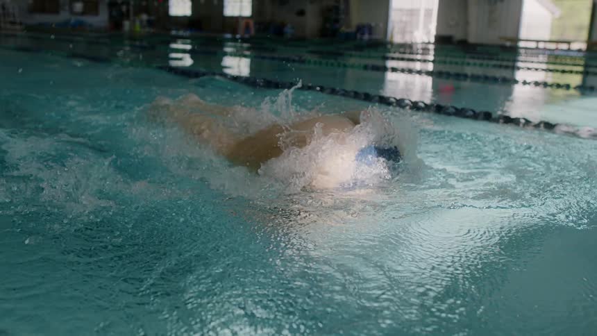 A woman is swimming in a pool
