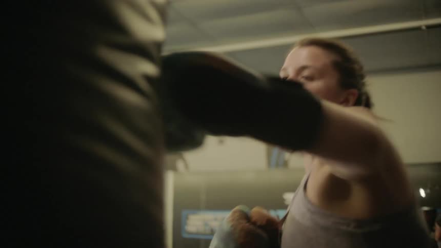 Woman hits a punching bag in a gym