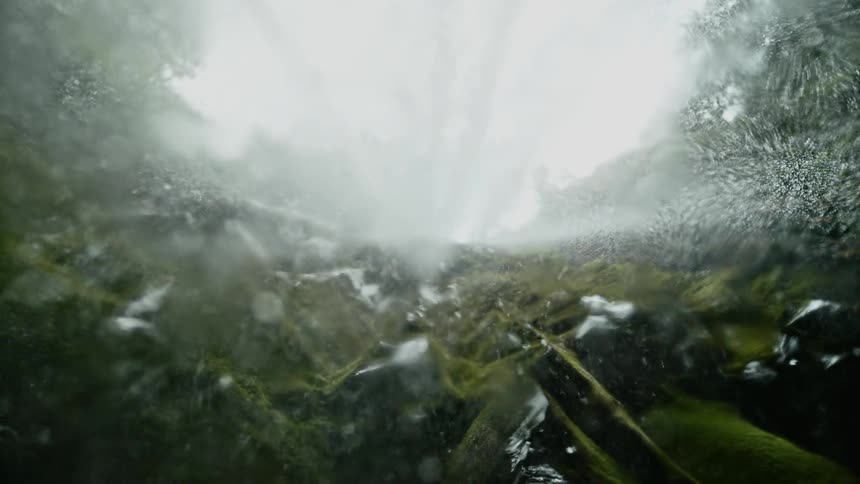 Slow motion water drops falling from waterfall