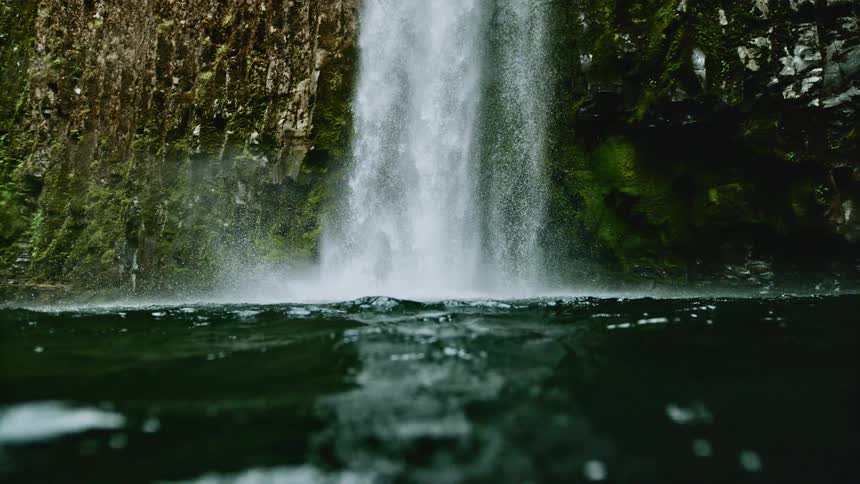 A waterfall splashing into a lake below