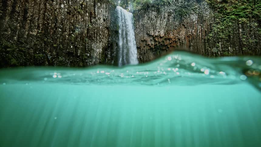 A waterfall flows into a body of water
