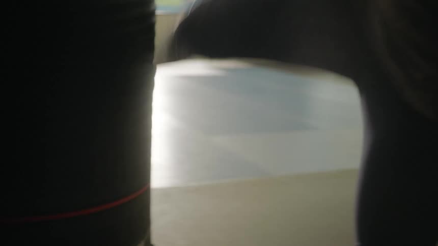A woman is kickboxing a heavy bag