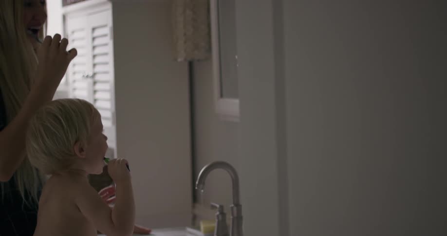 Mother and child brush their teeth