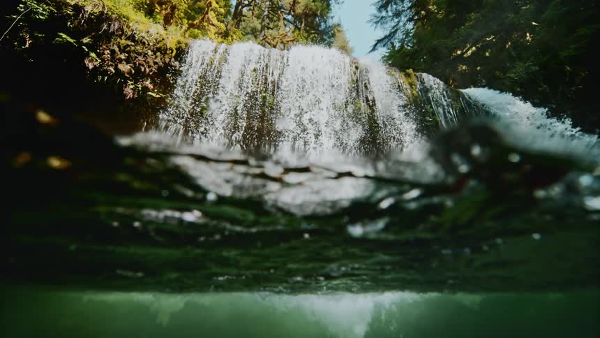 The waterfall slowly falls into the stream
