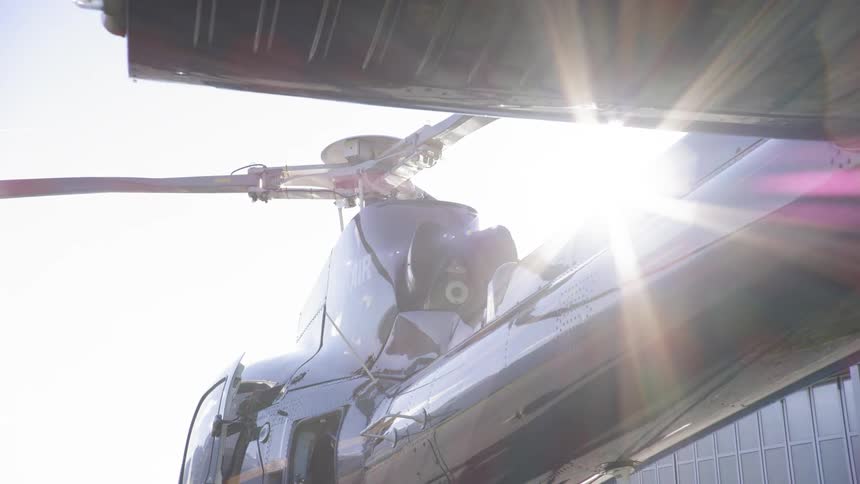 Sunlight shines down and reflects off a helicopter