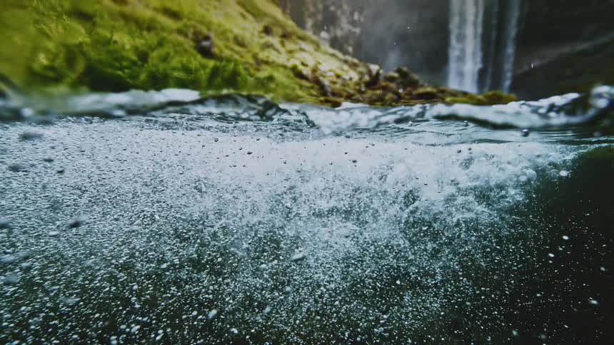 Bubbles forming in the water at the base of a waterfall