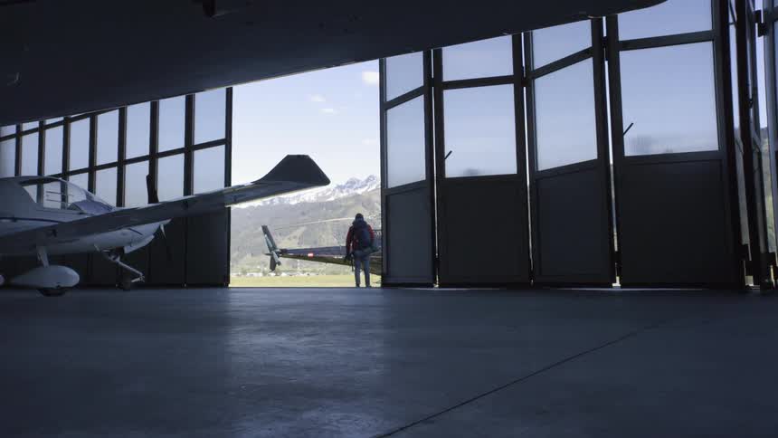 Man walking out of hangar towards a helicopter