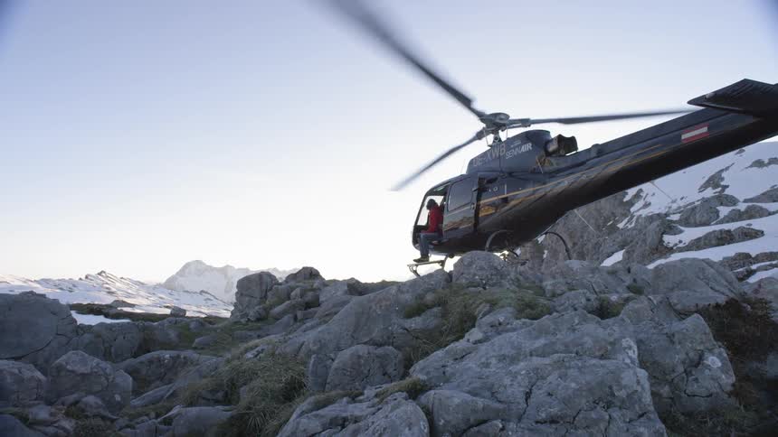 Man sits half out of grounded helicopter with open door