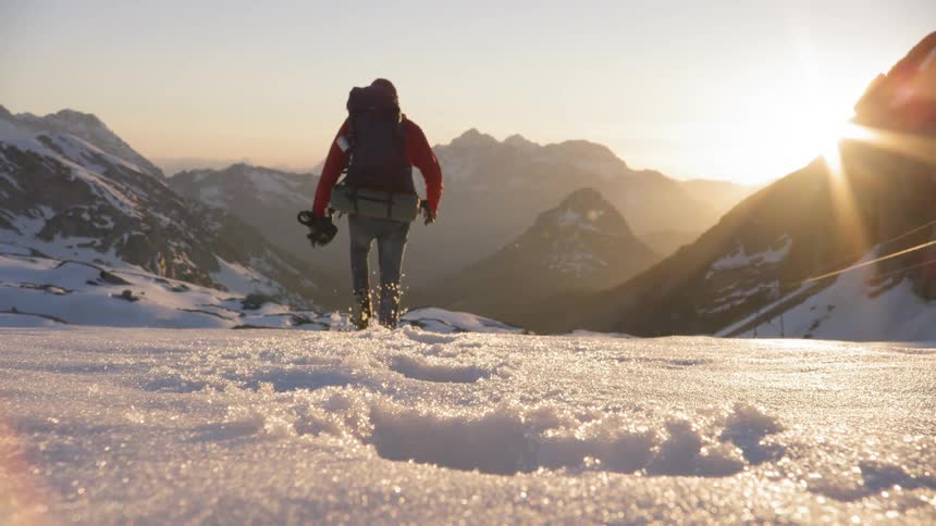 A man walks through the snow in the mountains
