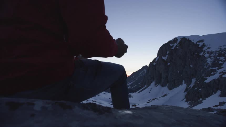 A person is sitting on the mountain top