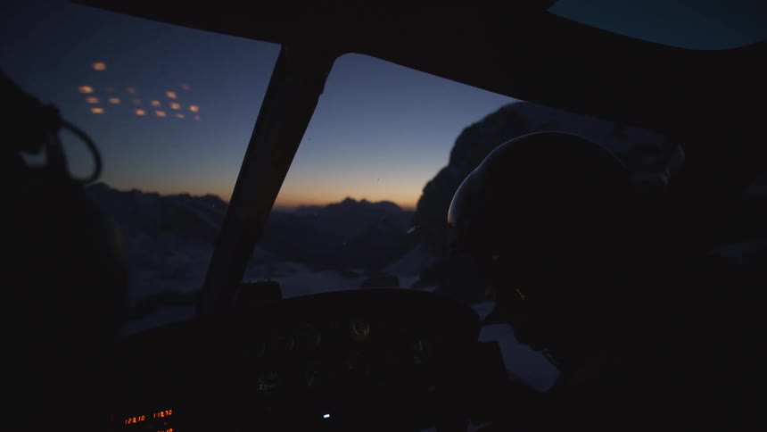 A helicopter waits to takeoff at night