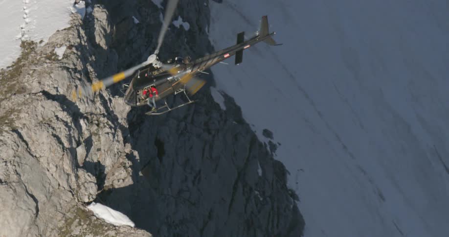A helicopter flies over the mountains