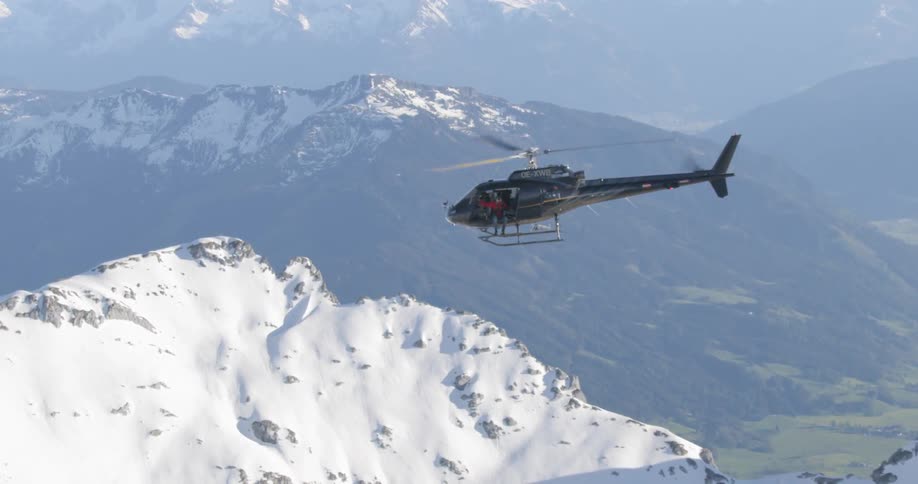 A helicopter flying in top of a mountain