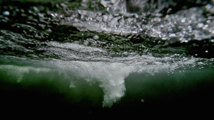 Bubbles ripple beneath the surface of a lake