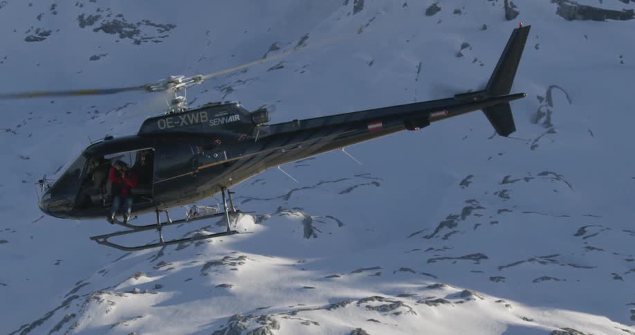 A view of a helicopter flying at the snowy mountain